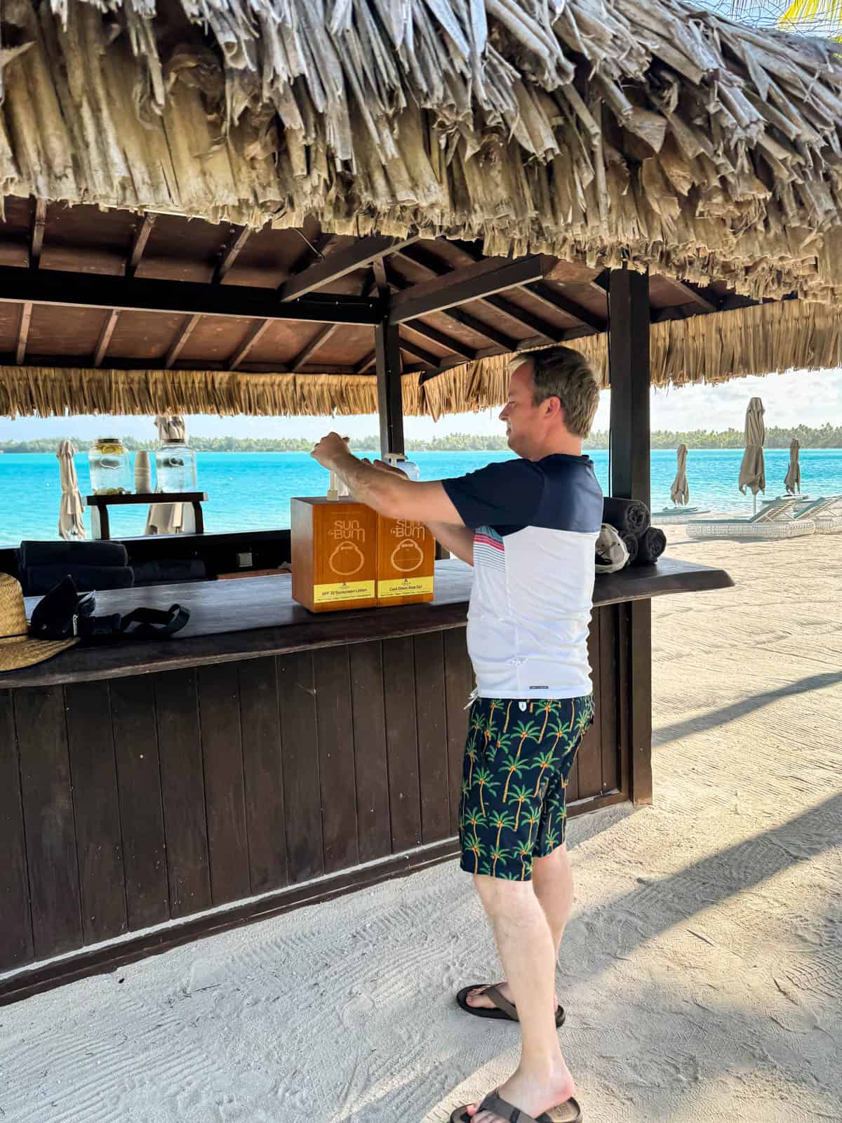 An image of a man getting sunscreen from a beach station in Bora Bora.