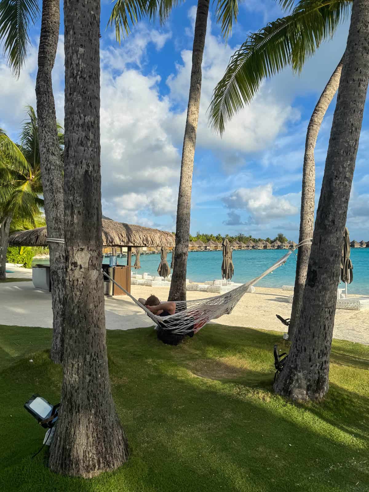 An image of a man relaxing in a hammock at the St. Regis Bora Bora.