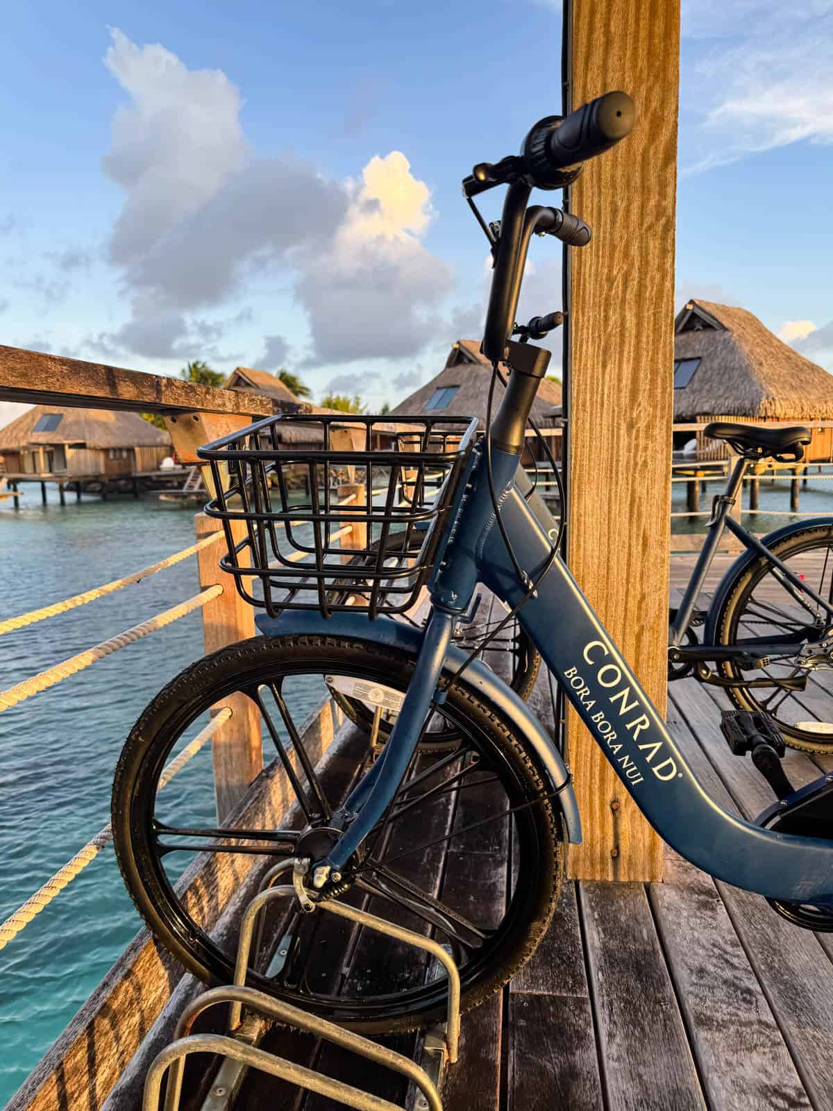 An image of a bicycle with a basket and the Conrad logo in Bora Bora.