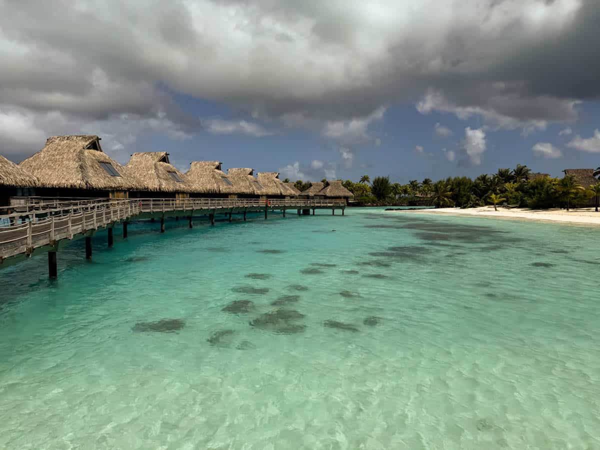 An image of over-the-water bungalows and the lagoon at the Conrad Bora Bora.