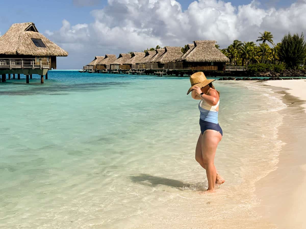 A woman stepping into the ocean in Bora Bora.