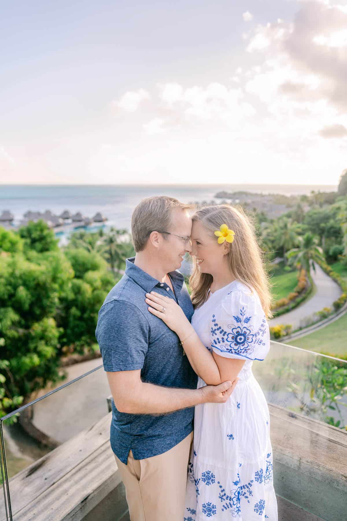 An image of a couple embracing on the top of a hillside in Bora Bora.