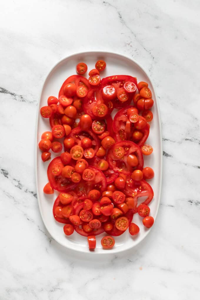 Arranging chopped tomatoes on a platter.