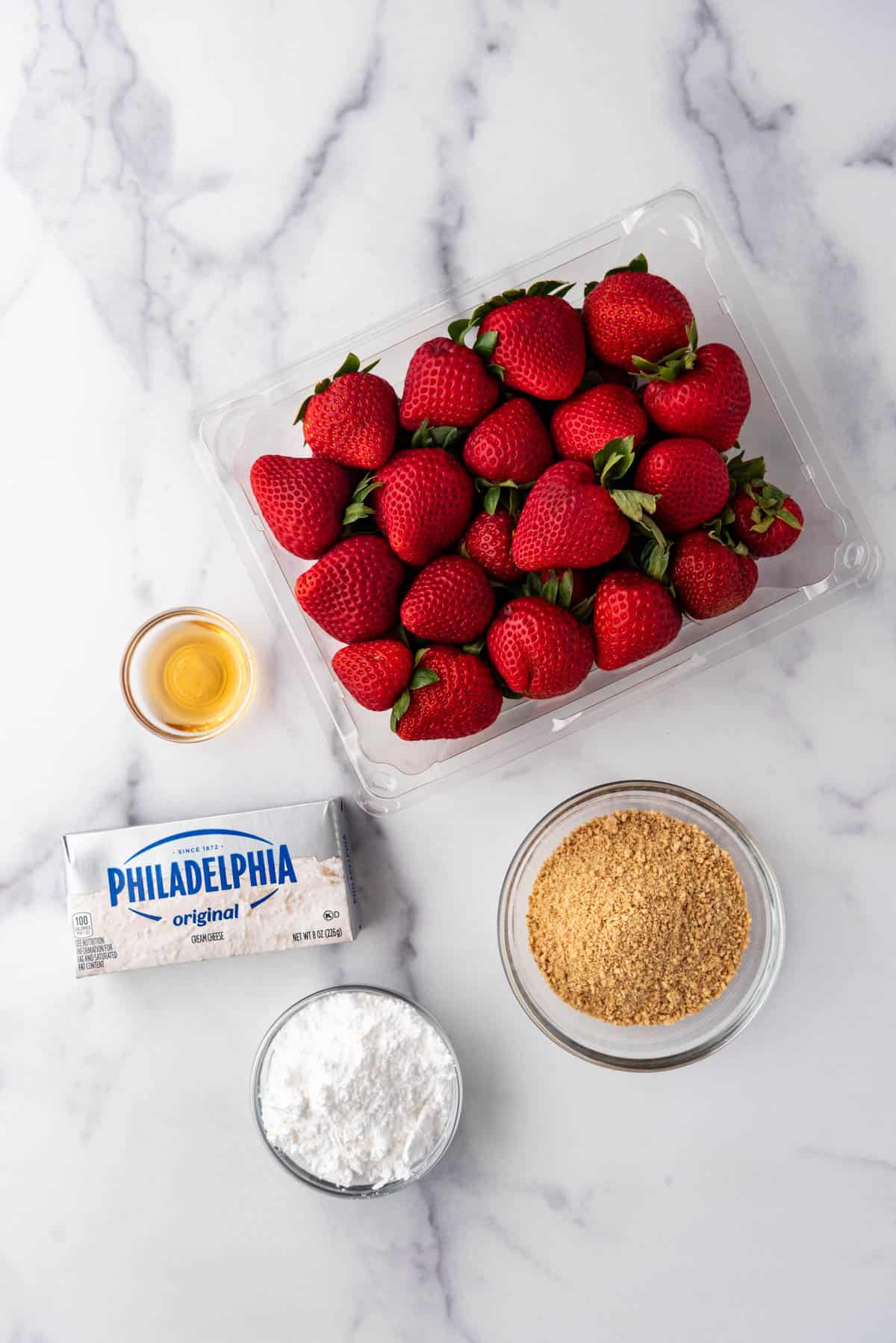 An overhead image of ingredients for making cheesecake stuffed strawberries.