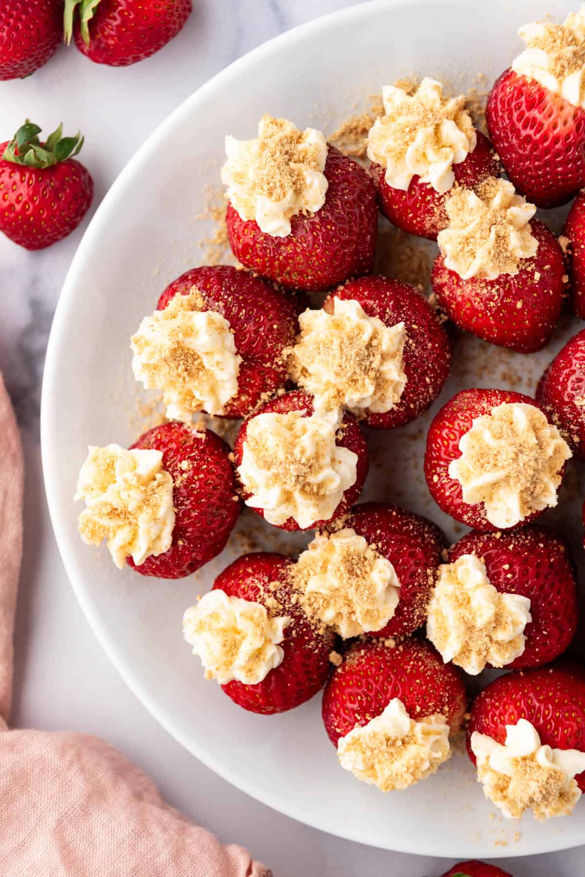 An overhead image of cheesecake stuffed strawberries.