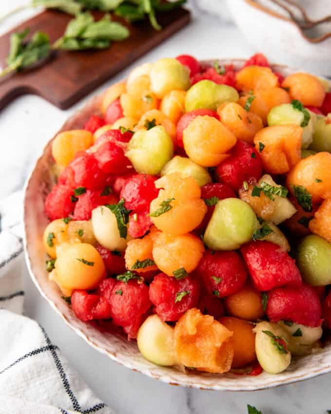 A side view of a large serving bowl of summer melon salad.