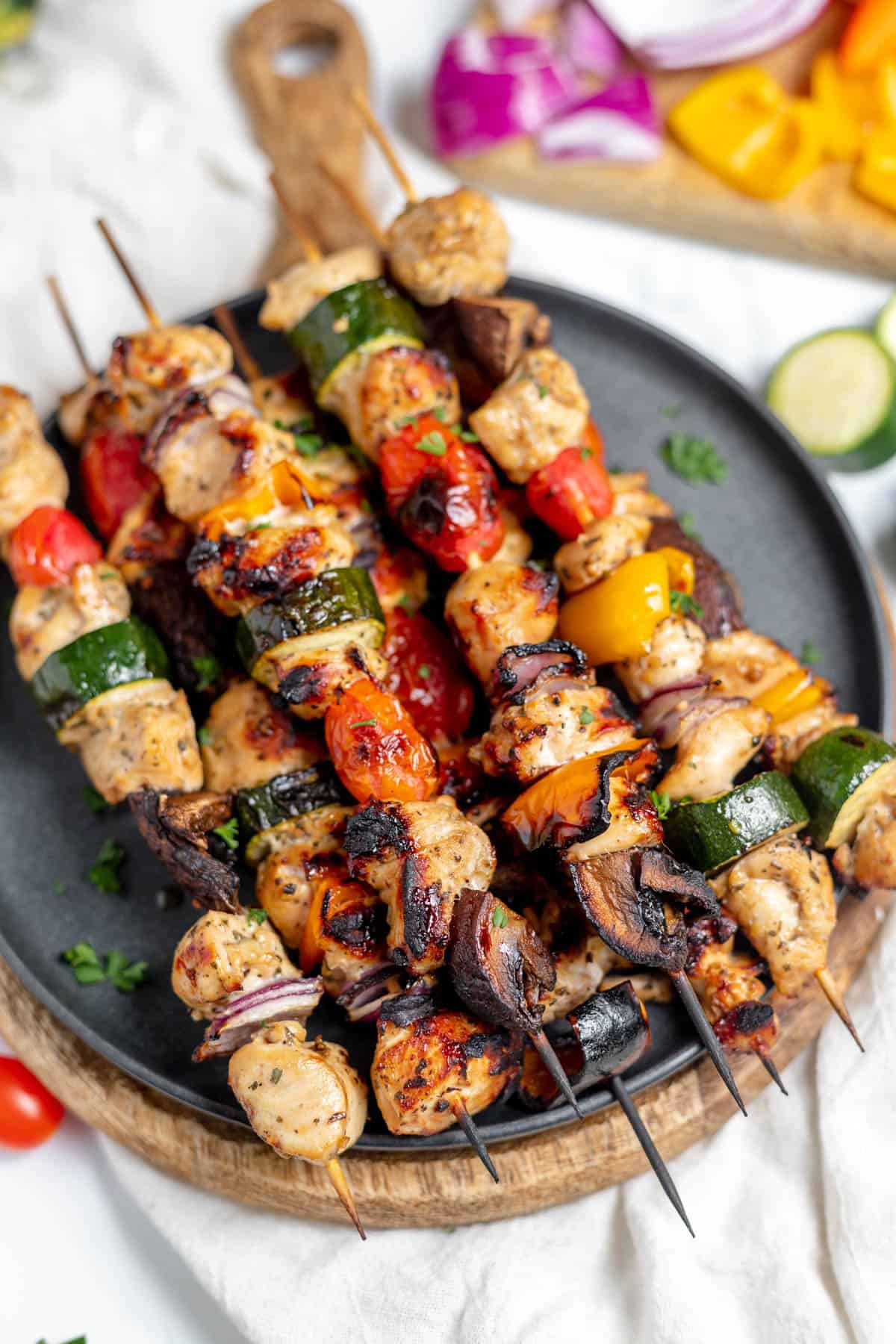 A close up image of grilled chicken kabobs on a plate.