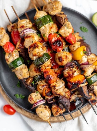 An overhead image of grilled chicken kabobs on a plate.