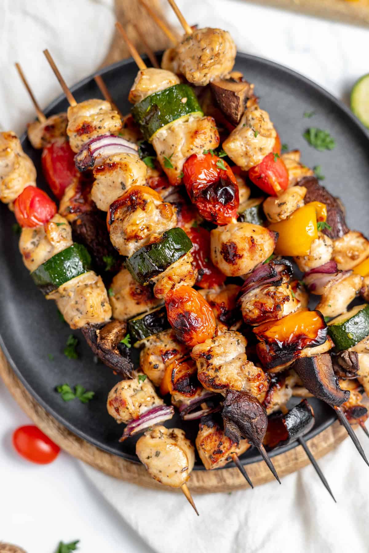 An overhead image of grilled chicken kabobs on a plate.