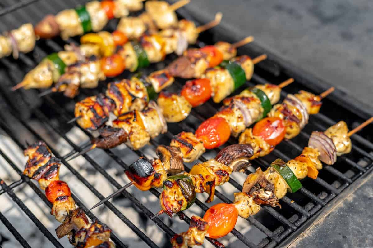 Grilled chicken kabobs on a charcoal grill.