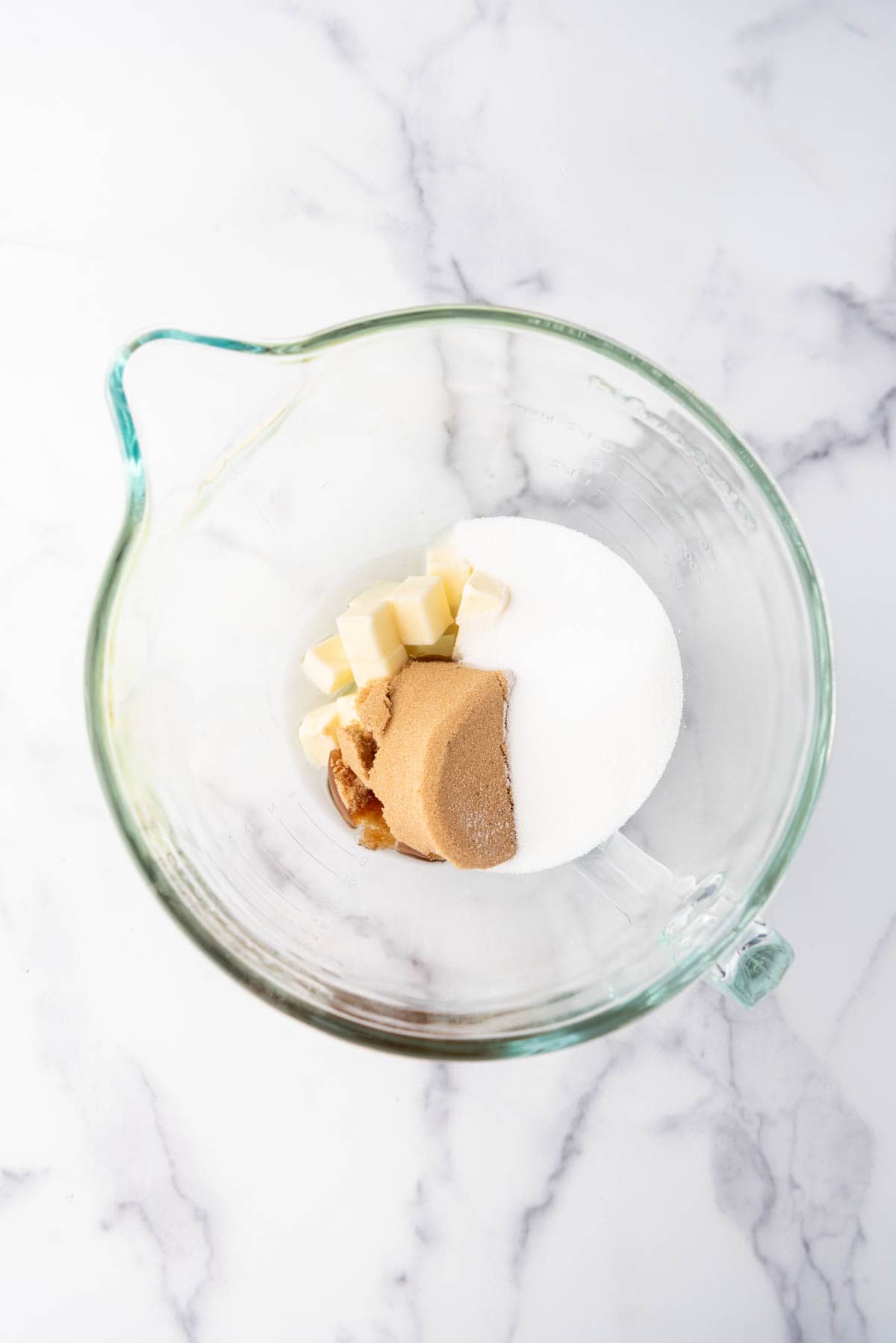 Combining sugars, butter, and oil in a large mixing bowl.