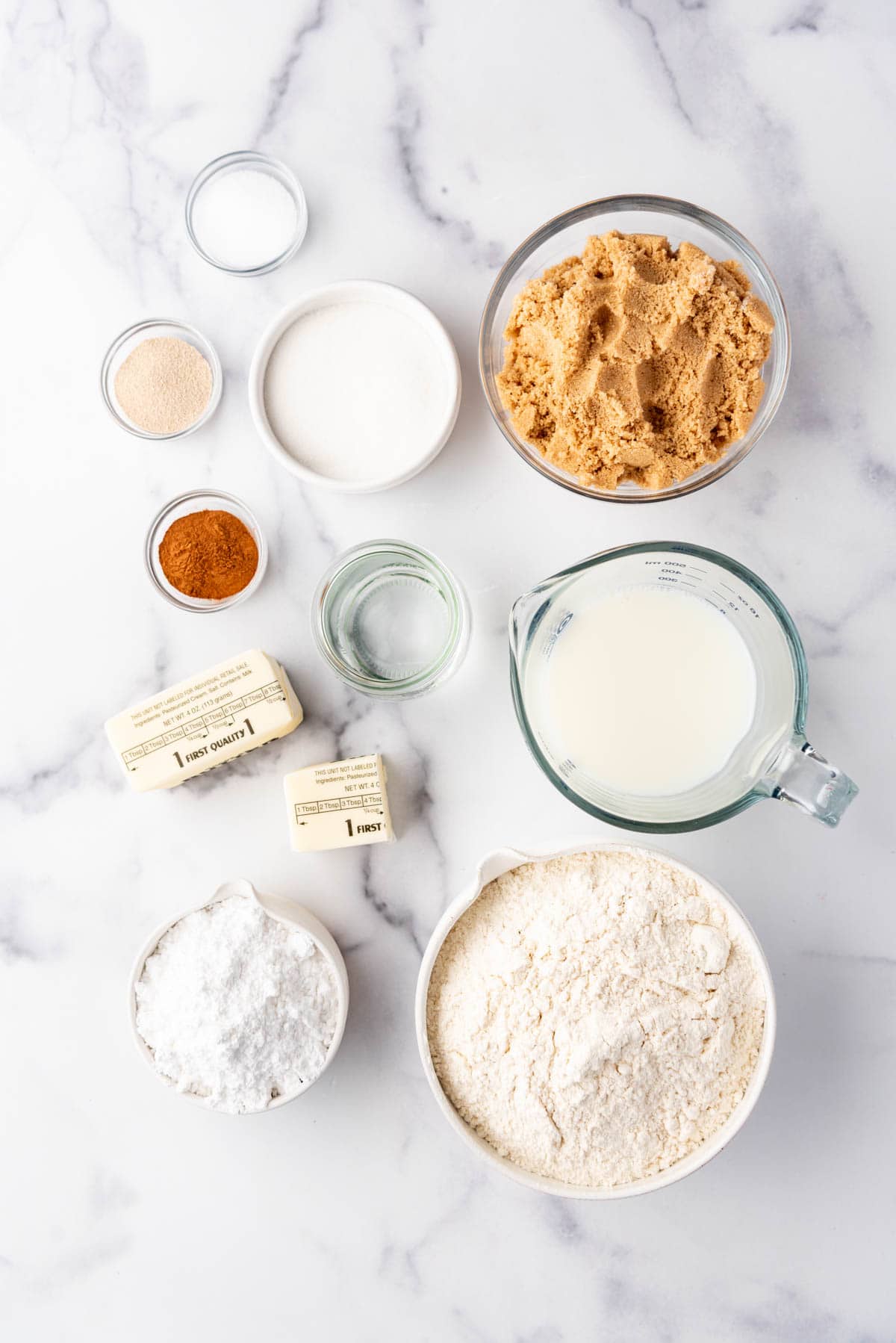 Ingredients for making homemade monkey bread on a white marble surface.