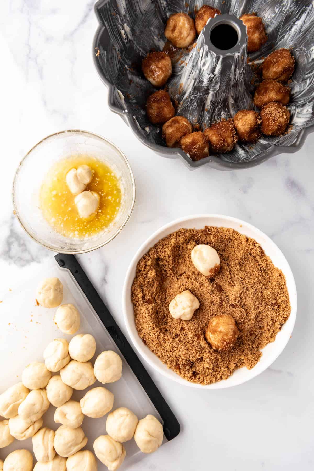 Rolling balls of dough into melted butter, then in a brown sugar cinnamon mixture before placing them in a bundt pan.