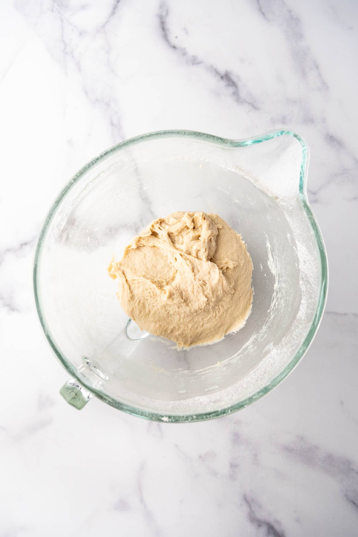 Kneaded dough in a glass mixing bowl.