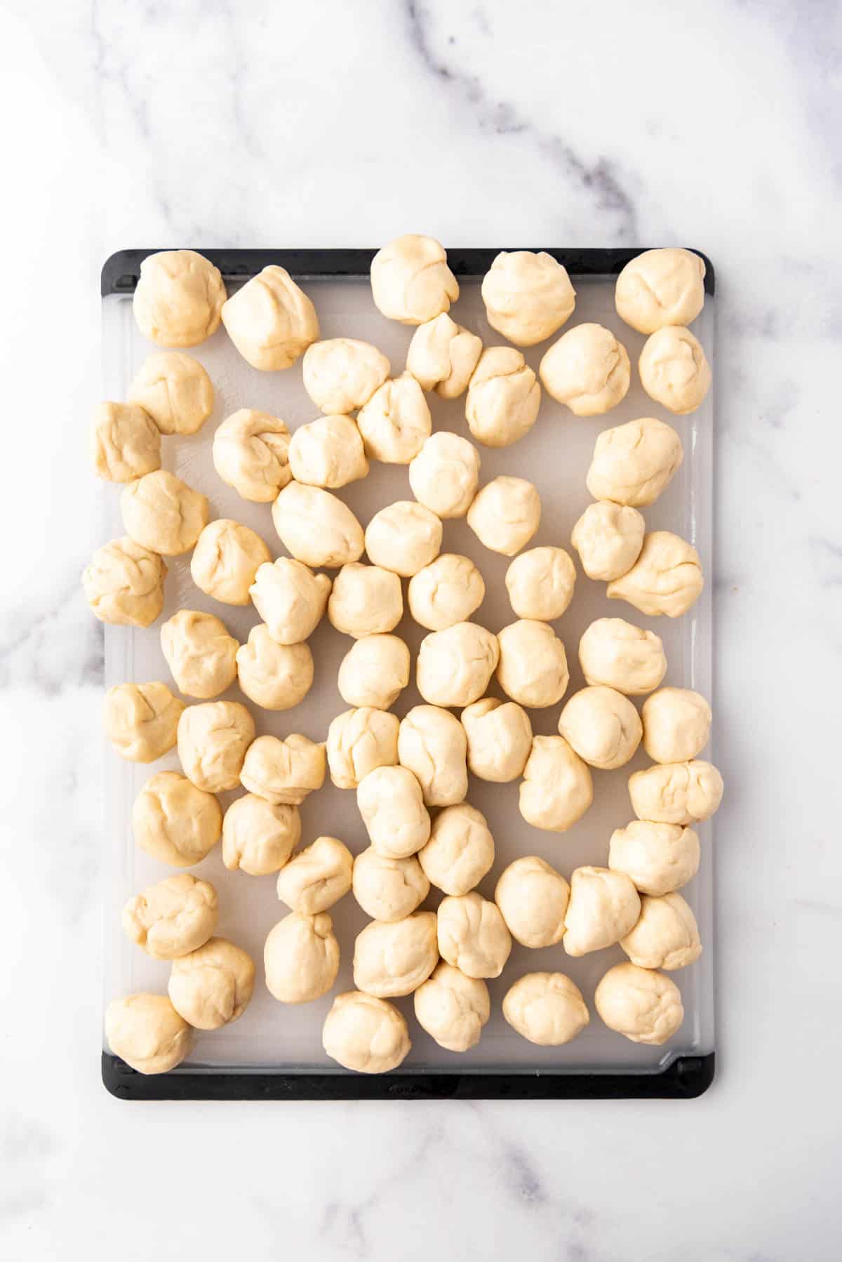 Rolling bread dough into small balls.