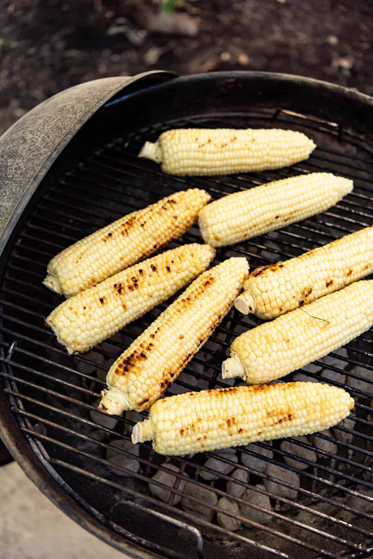 An image of shucked ears of corn on a charcoal grill.