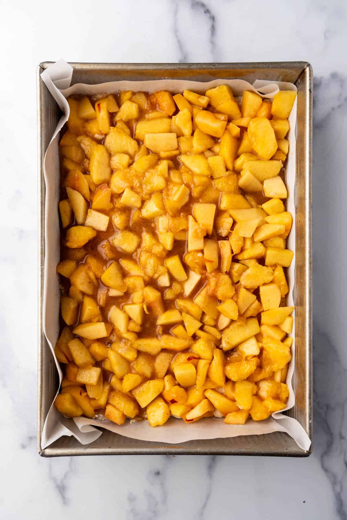 A layer of peach filling spread into a 9x13-inch pan.