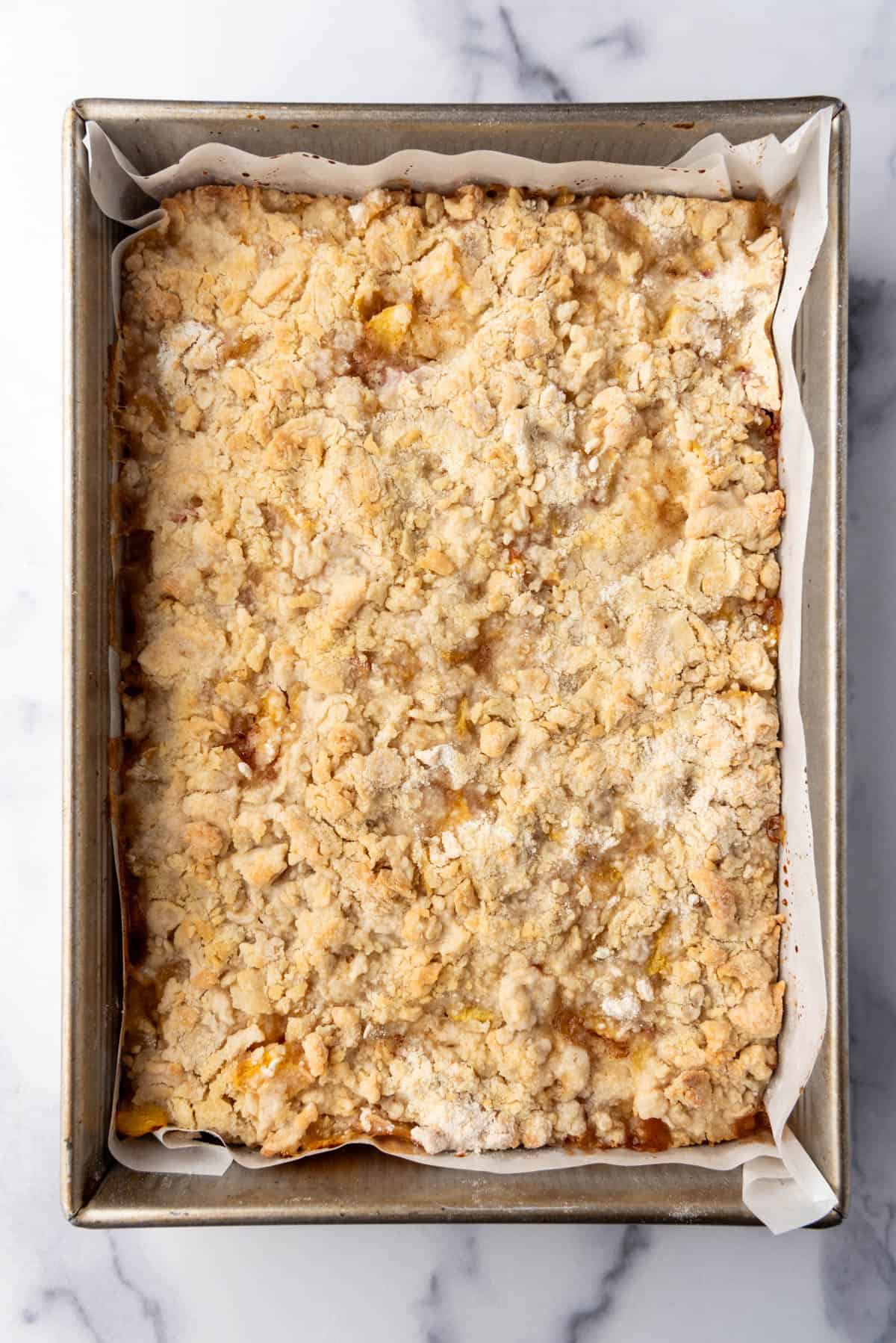 Baked peach pie bars in a metal baking dish.