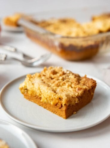 An image of a slice of pumpkin dump cake on a white plate.