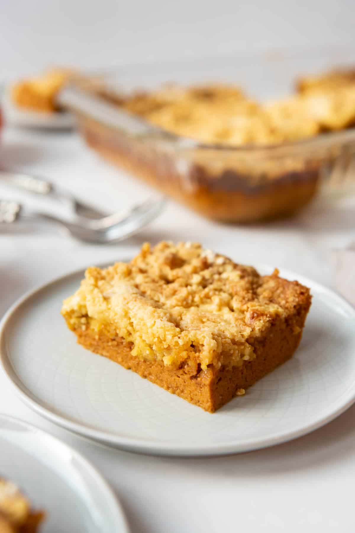 An image of a slice of pumpkin dump cake on a white plate.