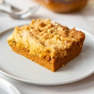 An image of a slice of pumpkin dump cake on a white plate.