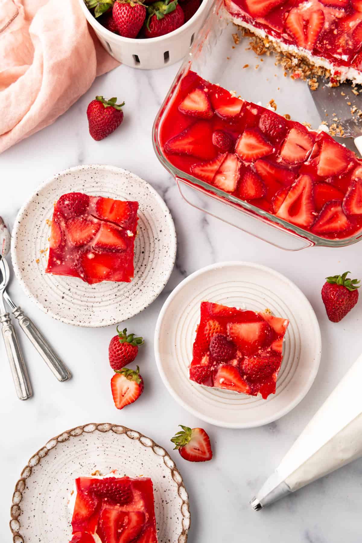 An overhead image of squares of strawberry pretzel salad on plates.