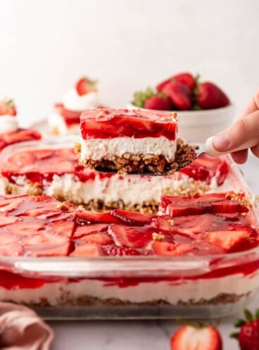 An image of a square of strawberry pretzel salad being lifted up out of the serving dish.