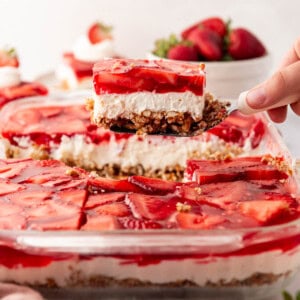 A piece of strawberry pretzel salad being lifted out of the pan.