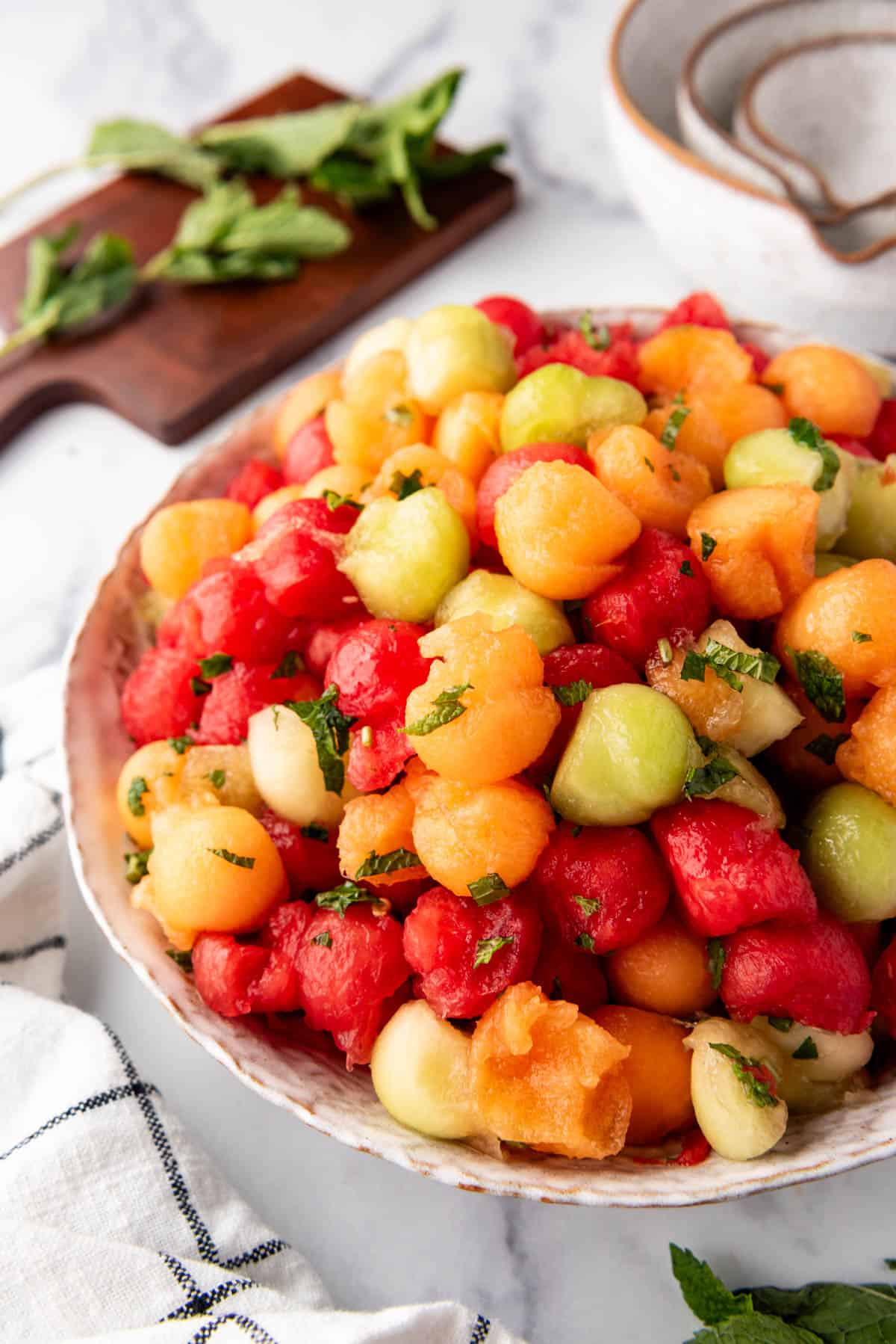 A side view of a large serving bowl of summer melon salad.