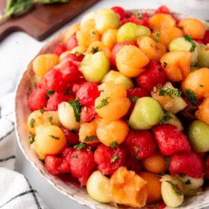 A side view of a large serving bowl of summer melon salad.