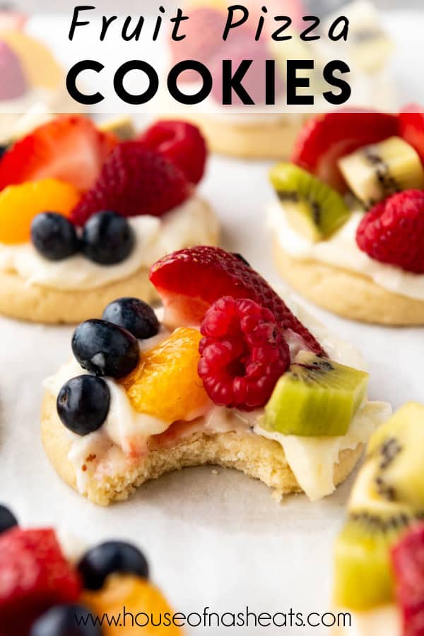 A fruit pizza cookie with a bite taken out of it with text overlay.