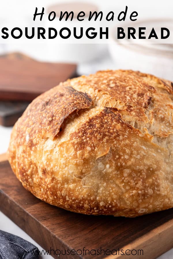 A loaf of homemade sourdough bread on a wooden cutting board with text overlay.