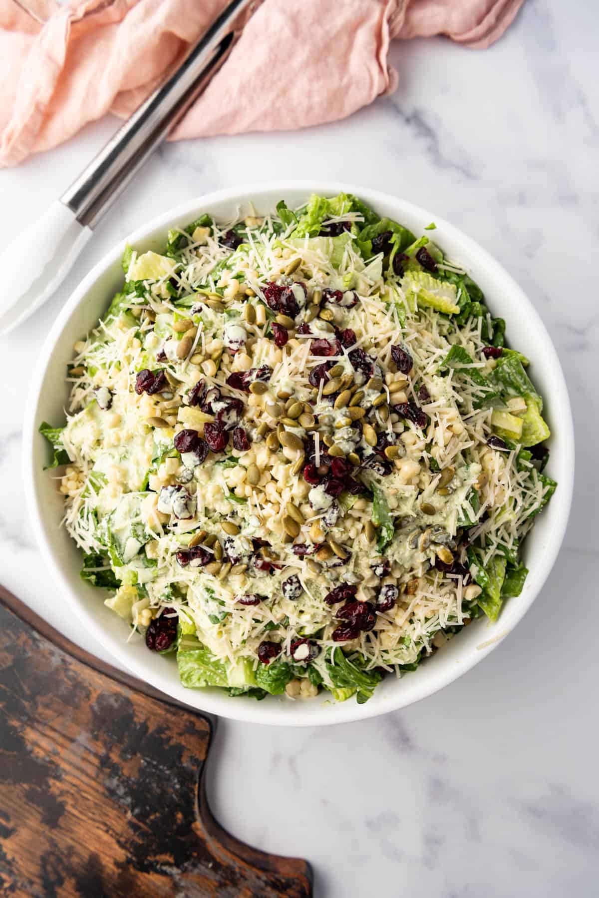 An overhead image of a large bowl of basil couscous salad.