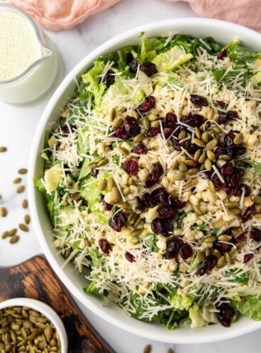 An overhead image of a large bowl of basil couscous salad.