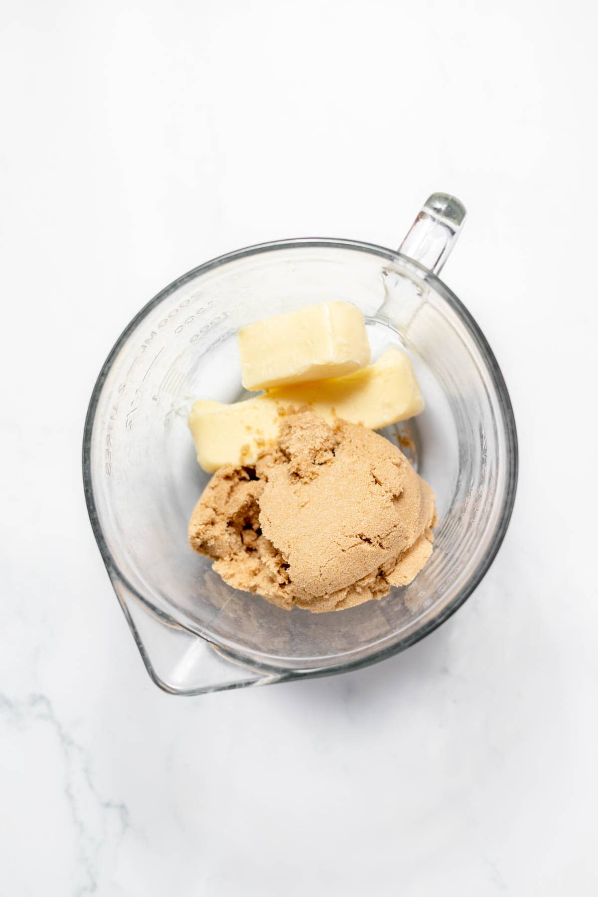 Combining softened butter and brown sugar in a large glass mixing bowl.