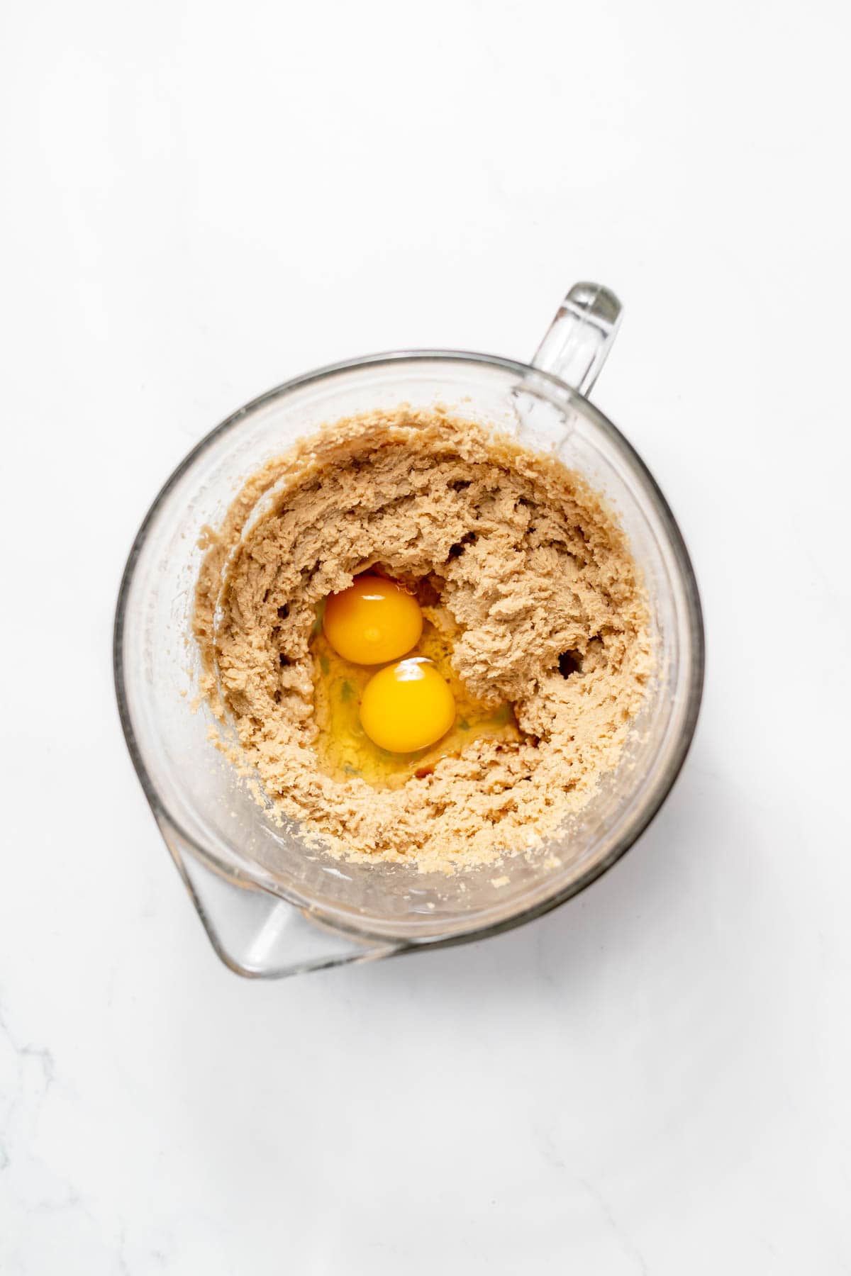 Adding eggs to creamed butter and sugar.