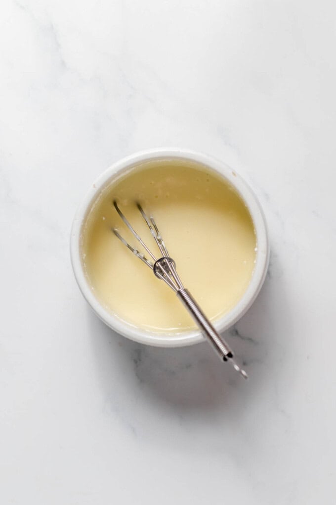 An easy vanilla glaze in a bowl with a whisk.