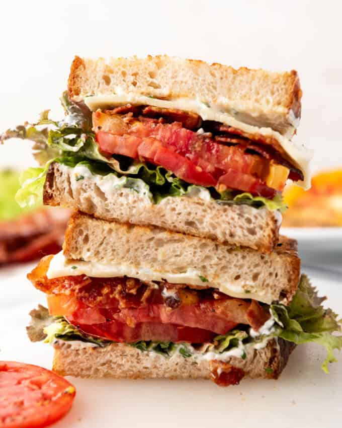 A BLT sandwich that has been sliced in half and stacked.