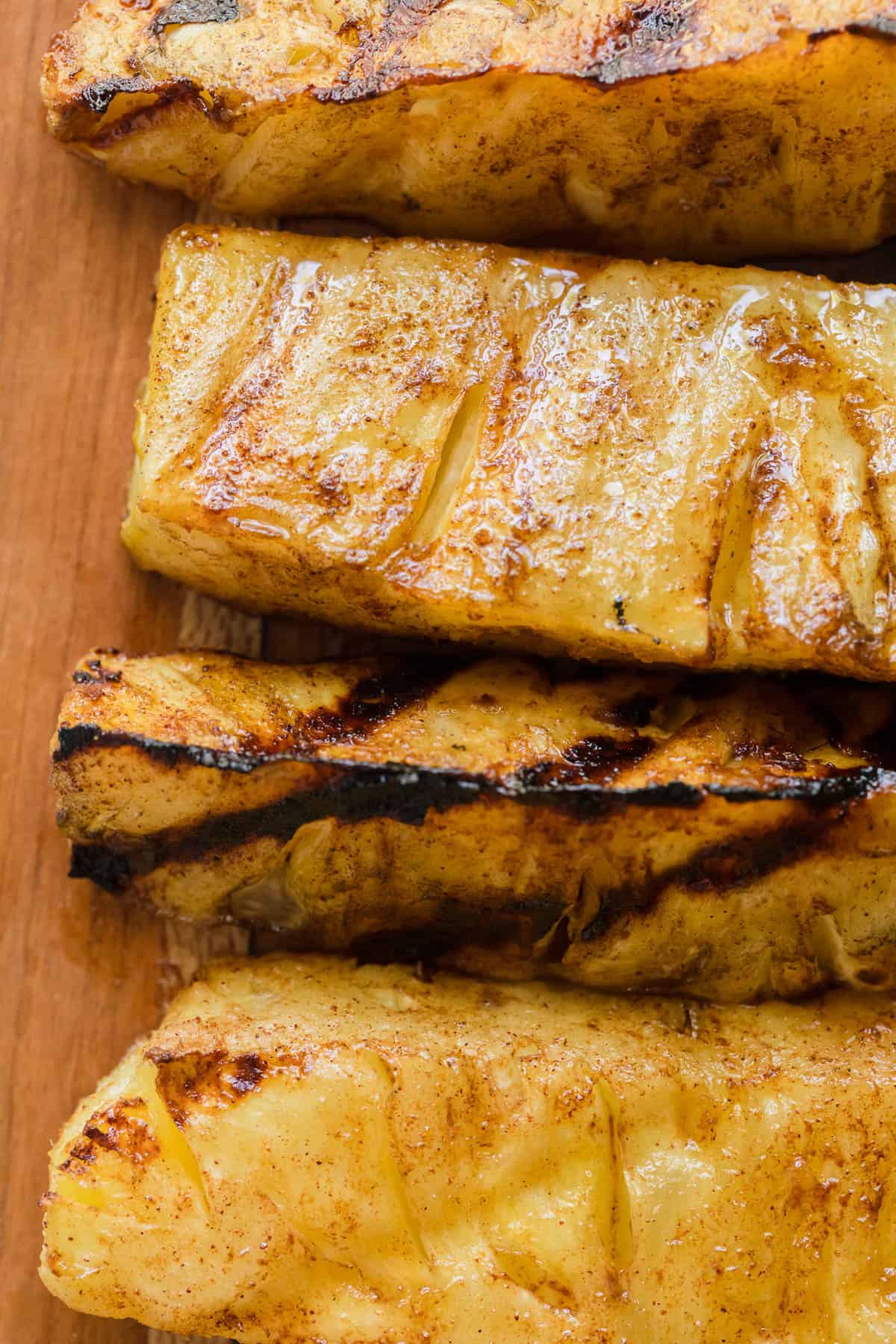 A close up overhead image of grilled pineapple spears.