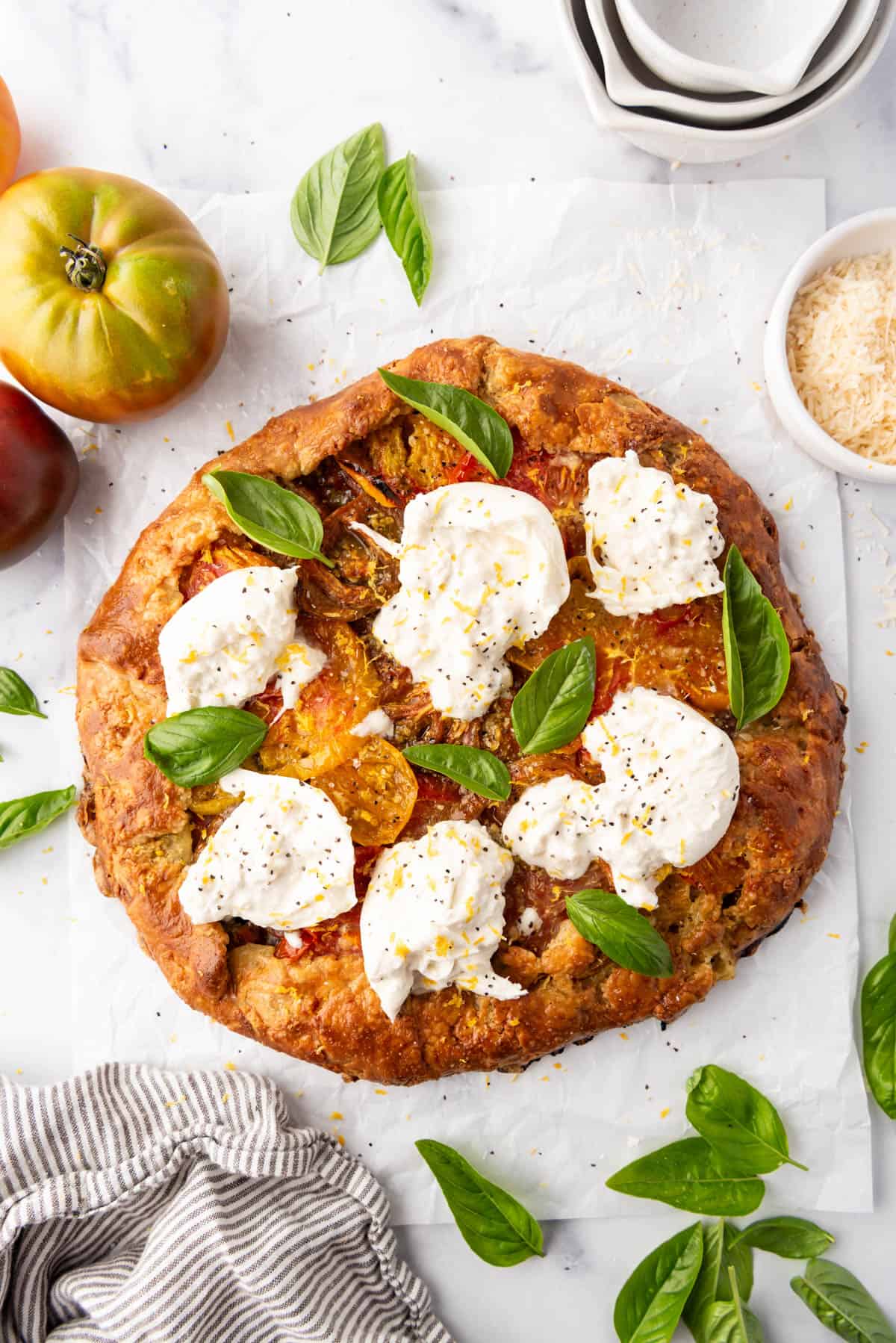 Une image d'une galette de tomates héritage avec du fromage burrata sur le dessus.