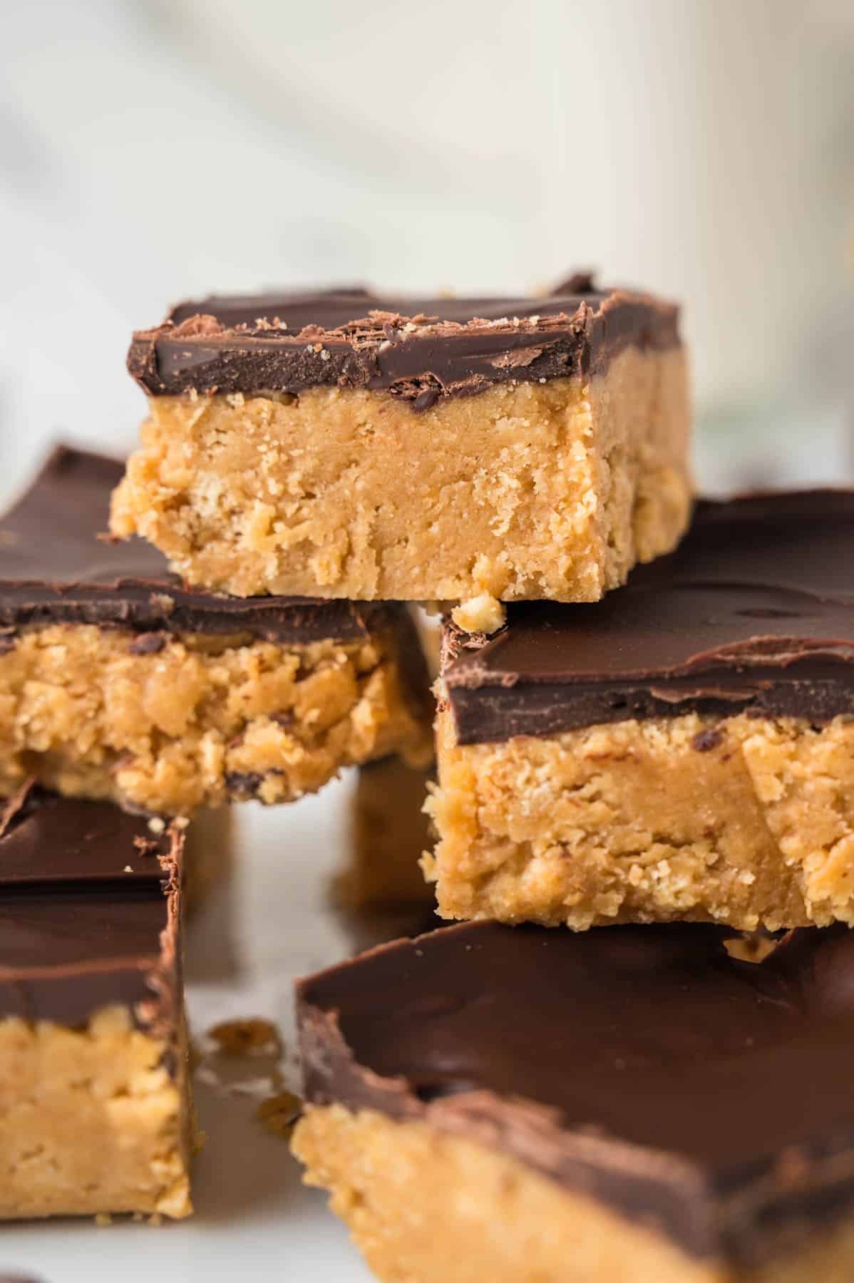 An image of stacked no-bake peanut butter bars with chocolate topping.