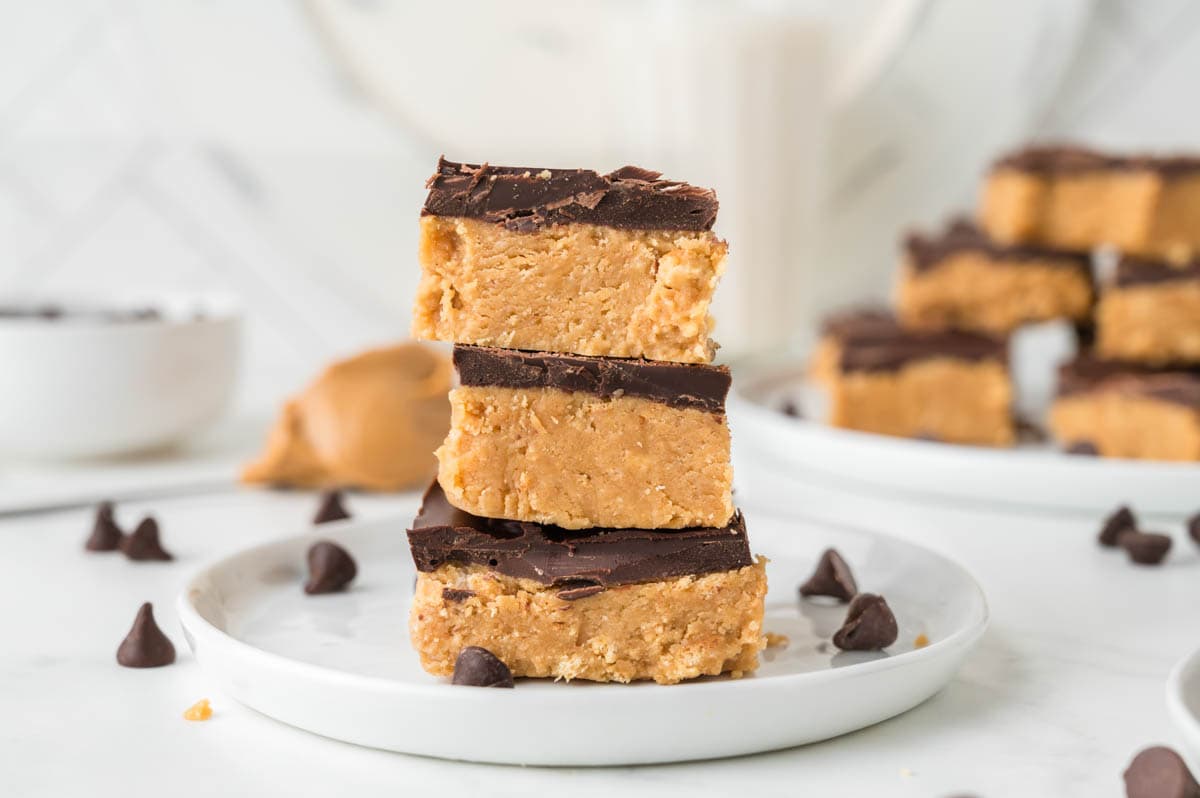 Three no-bake peanut butter bars stacked on top of each other.