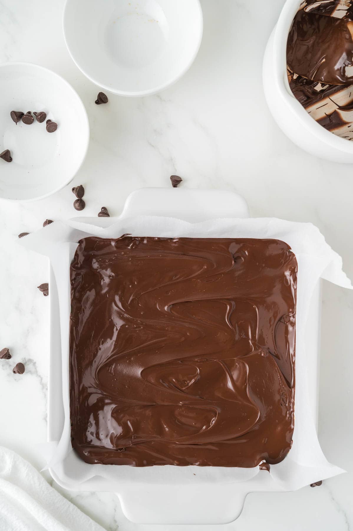 Melted chocolate spread  on top of no-bake peanut butter bars.