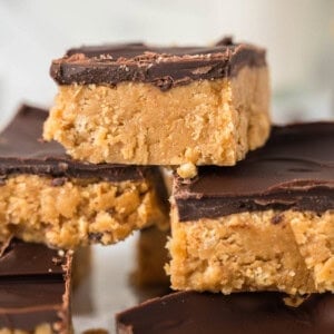 An image of stacked no-bake peanut butter bars with chocolate topping.