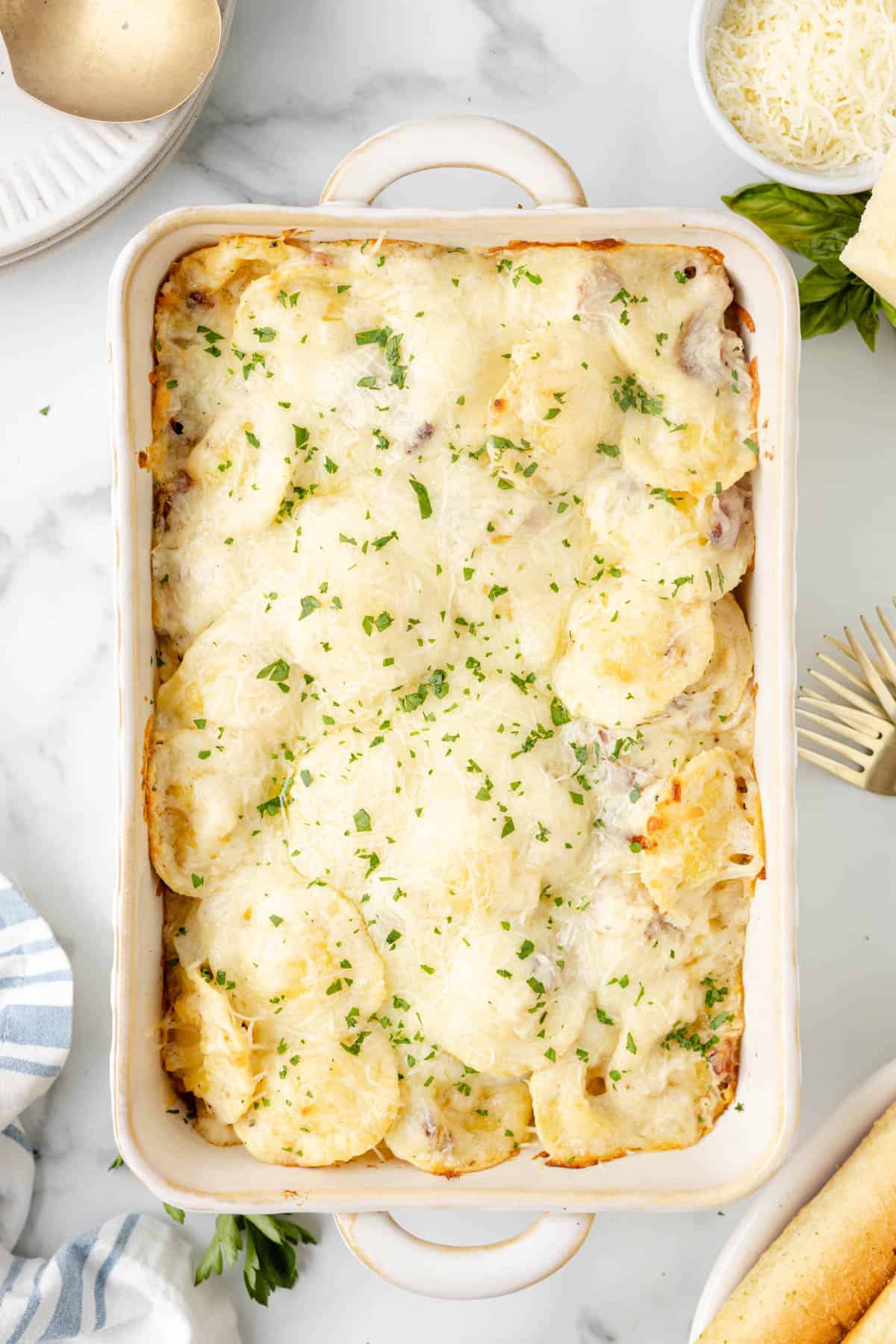 Baked ravioli carbonara sprinkled with chopped parsley.