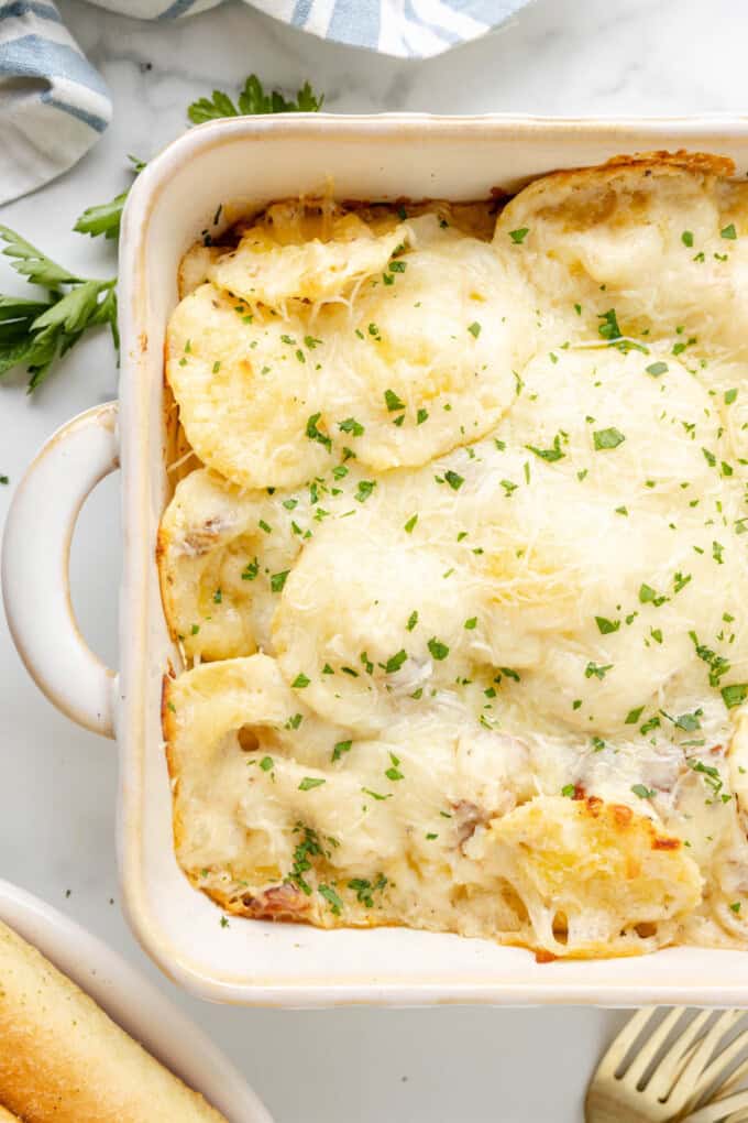 A close image of ravioli carbonara in a large baking dish.