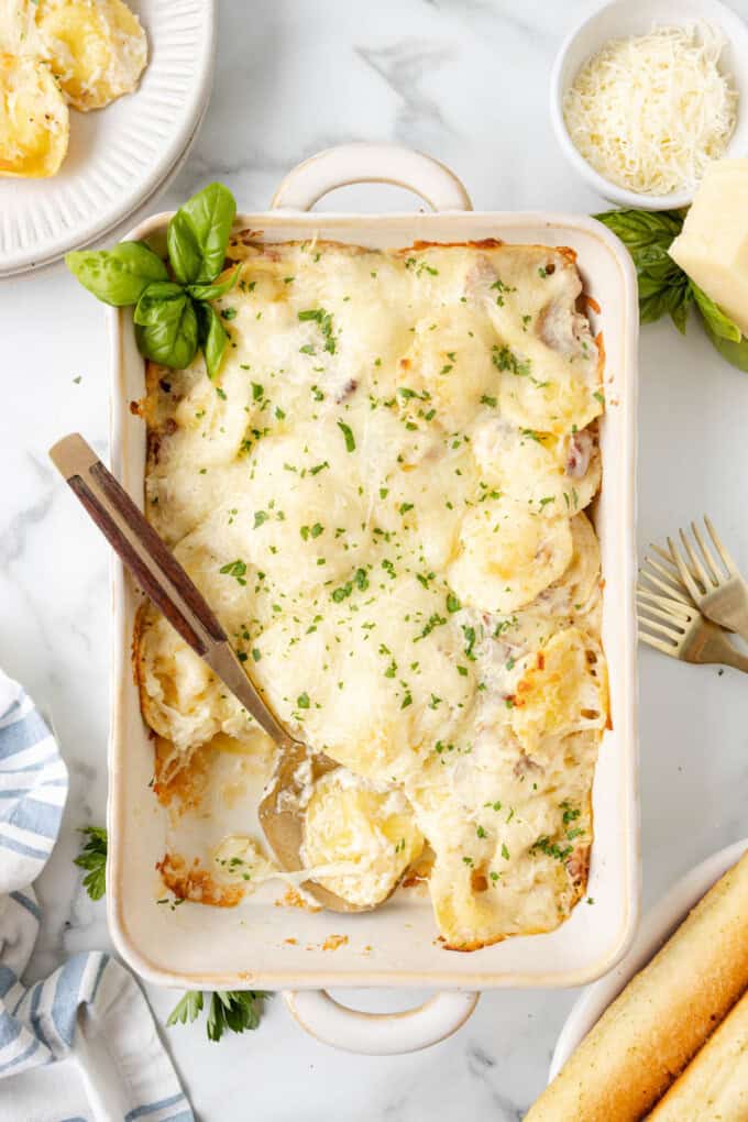 An overhead image of a large baking dish of homemade Olive Garden ravioli carbonara.