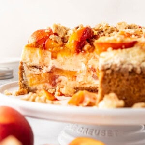 An image of a peach cobbler cheesecake with slices removed.