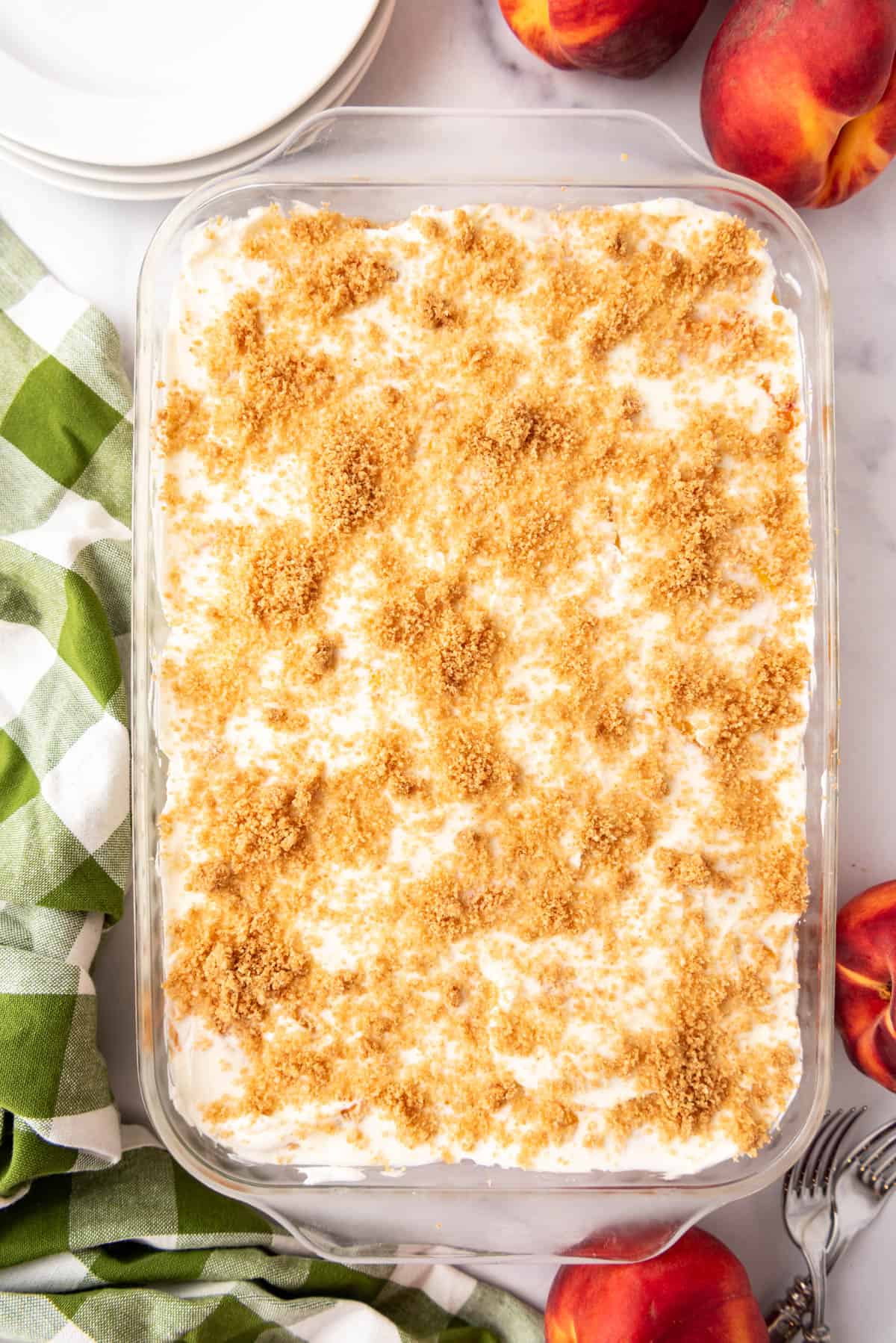 A finished peaches and cream dessert with graham cracker crumbs sprinkled on top.