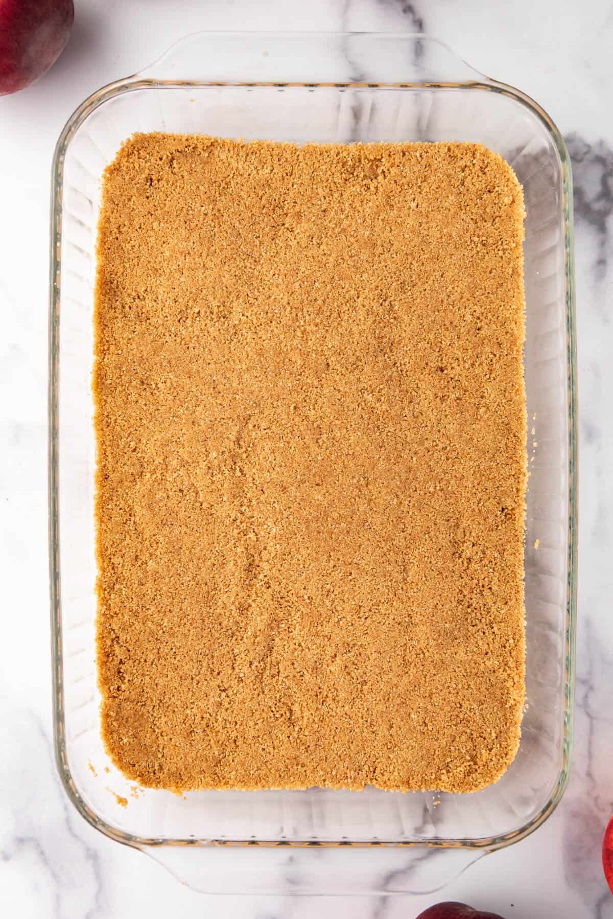 A graham cracker crust pressed into a 9x13-inch glass baking dish.